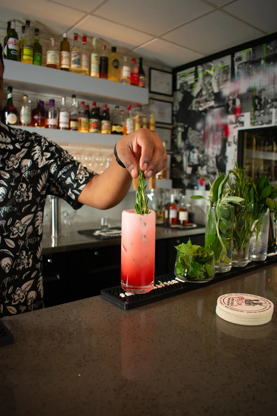 A bartender building a drink at the bar